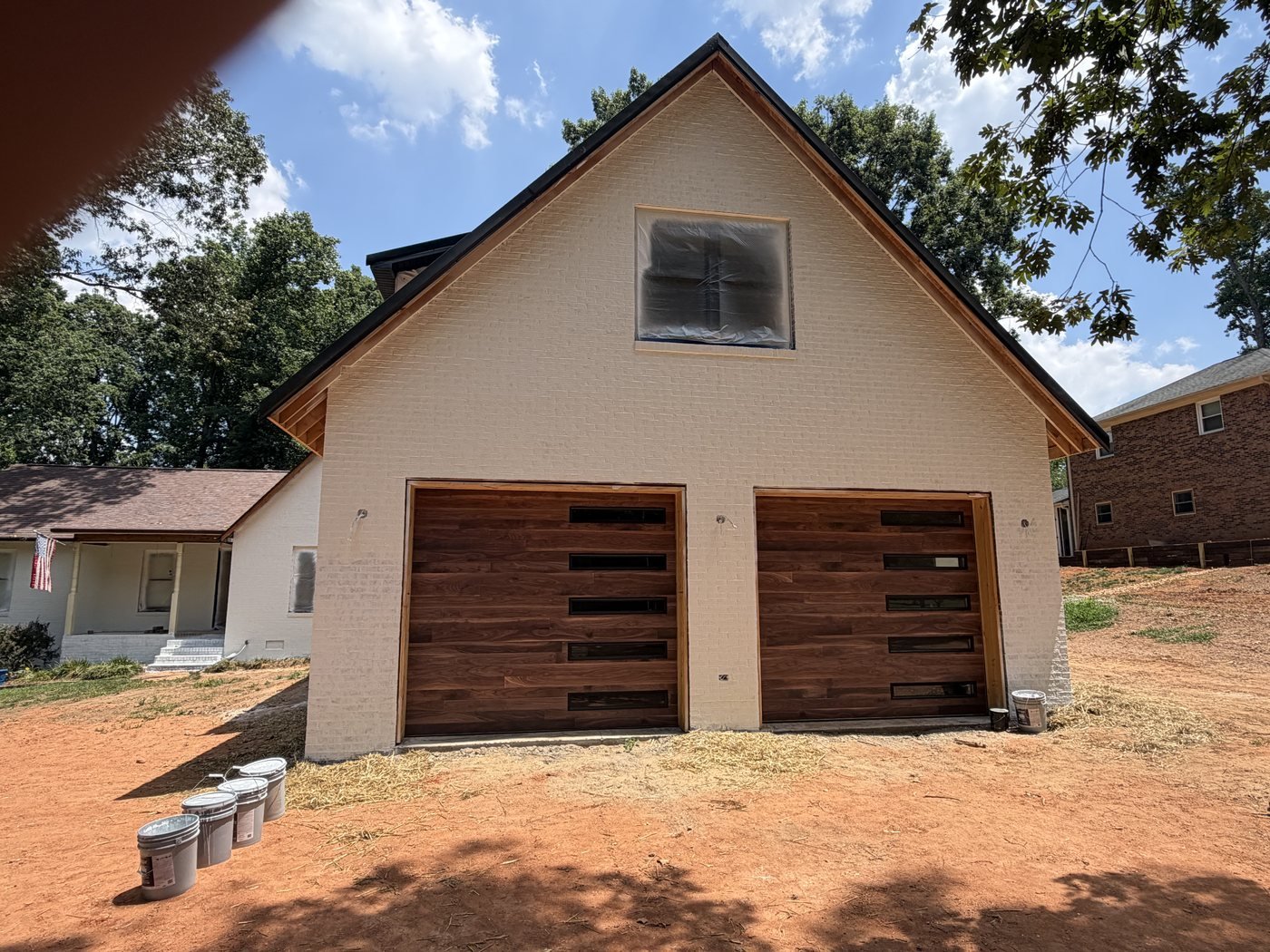 Modern walnut flush-panel garage doors with narrow black glass slots